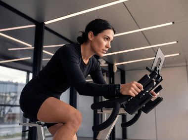 Determined-individual-cycling-on-exercise-bike-in-modern-gym