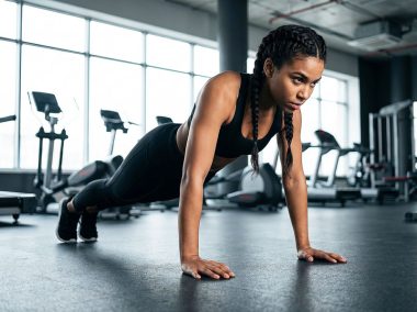 Sporty-woman-performing-push-ups-from-the-floor-in-the-gym